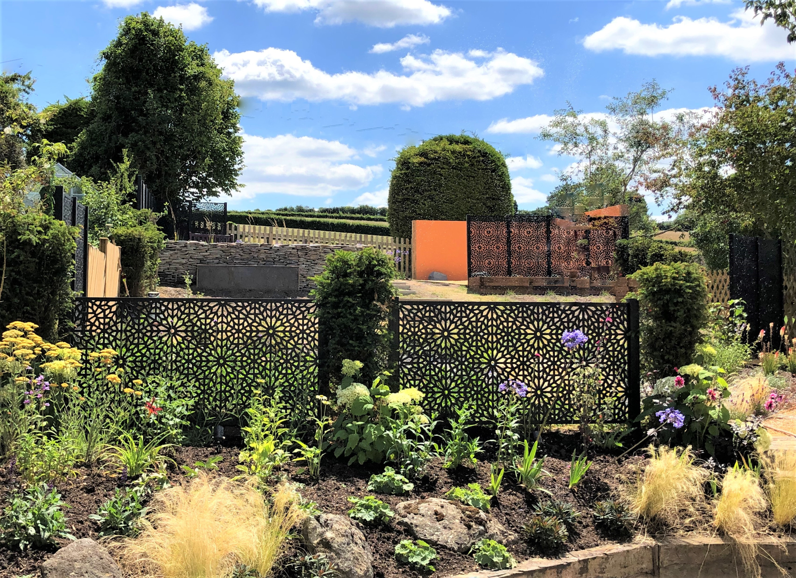 Creating a small room in a section of the garden Dense planting and Moroccan screens break up a large garden