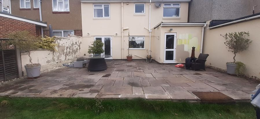 A rear view of a house and an old patio