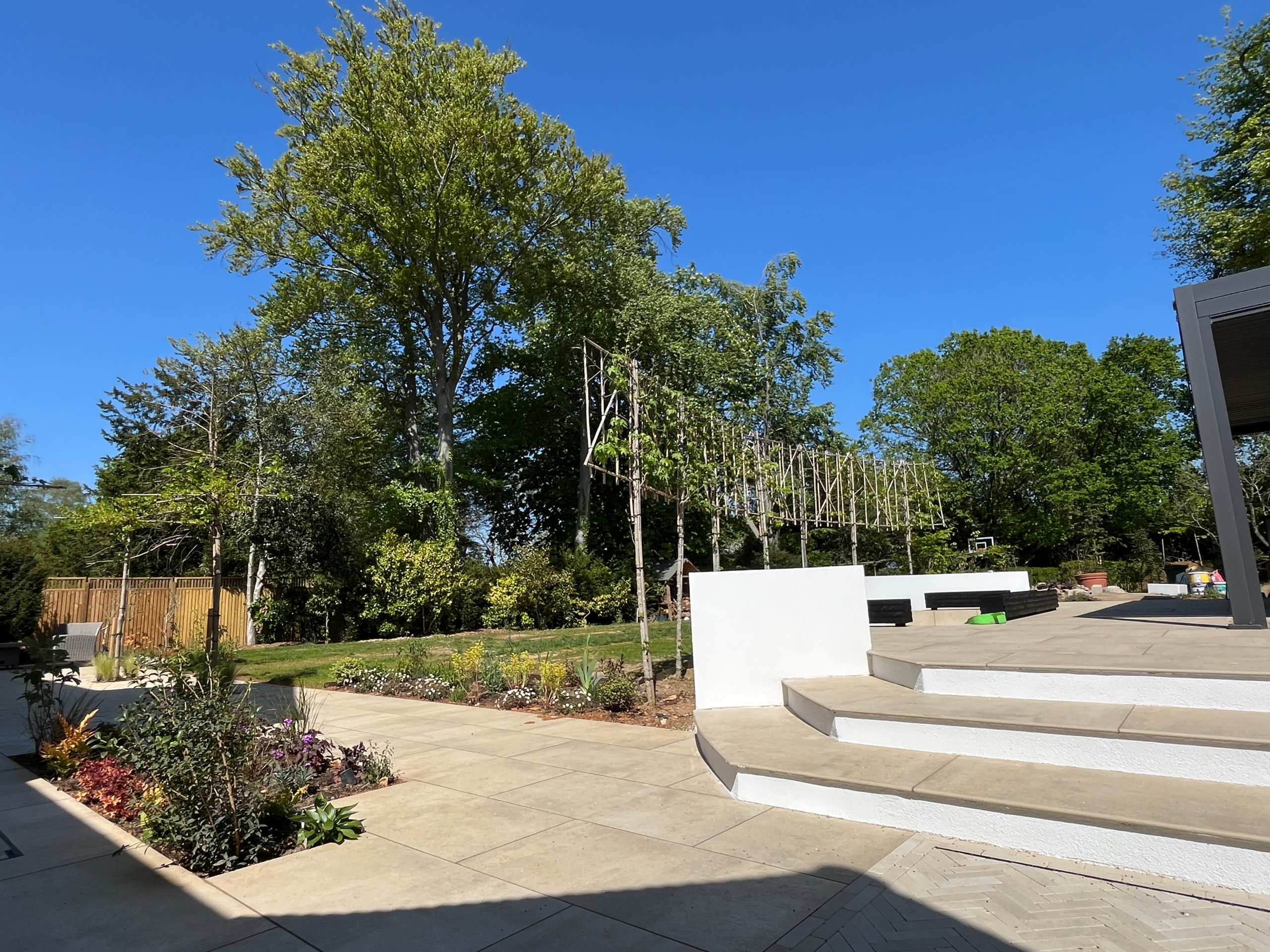 Wide garden steps lead to a sunken firepit and an outdoor kitchen