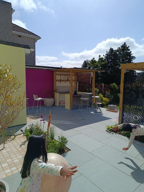 A patio with a bar and planting beds