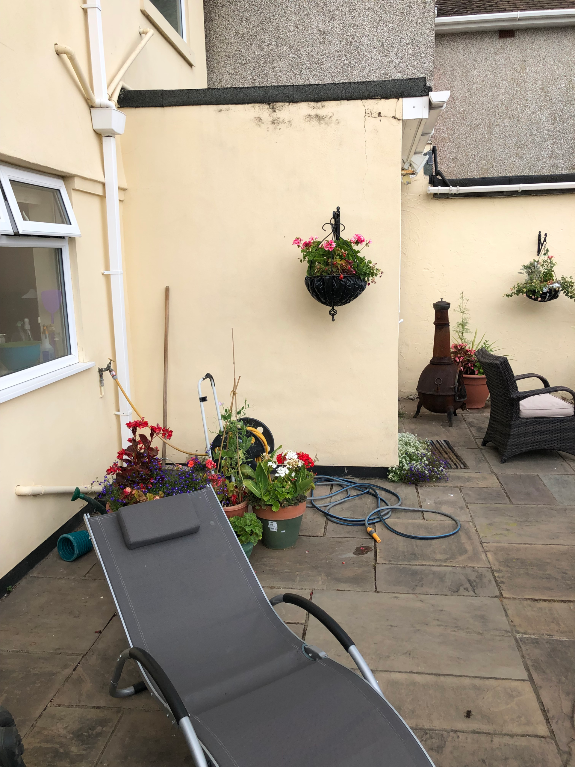 Before the transformation - the bare rendered walls Before - the plain rendered walls and weathered paving of the Bexley patio prior to redesign