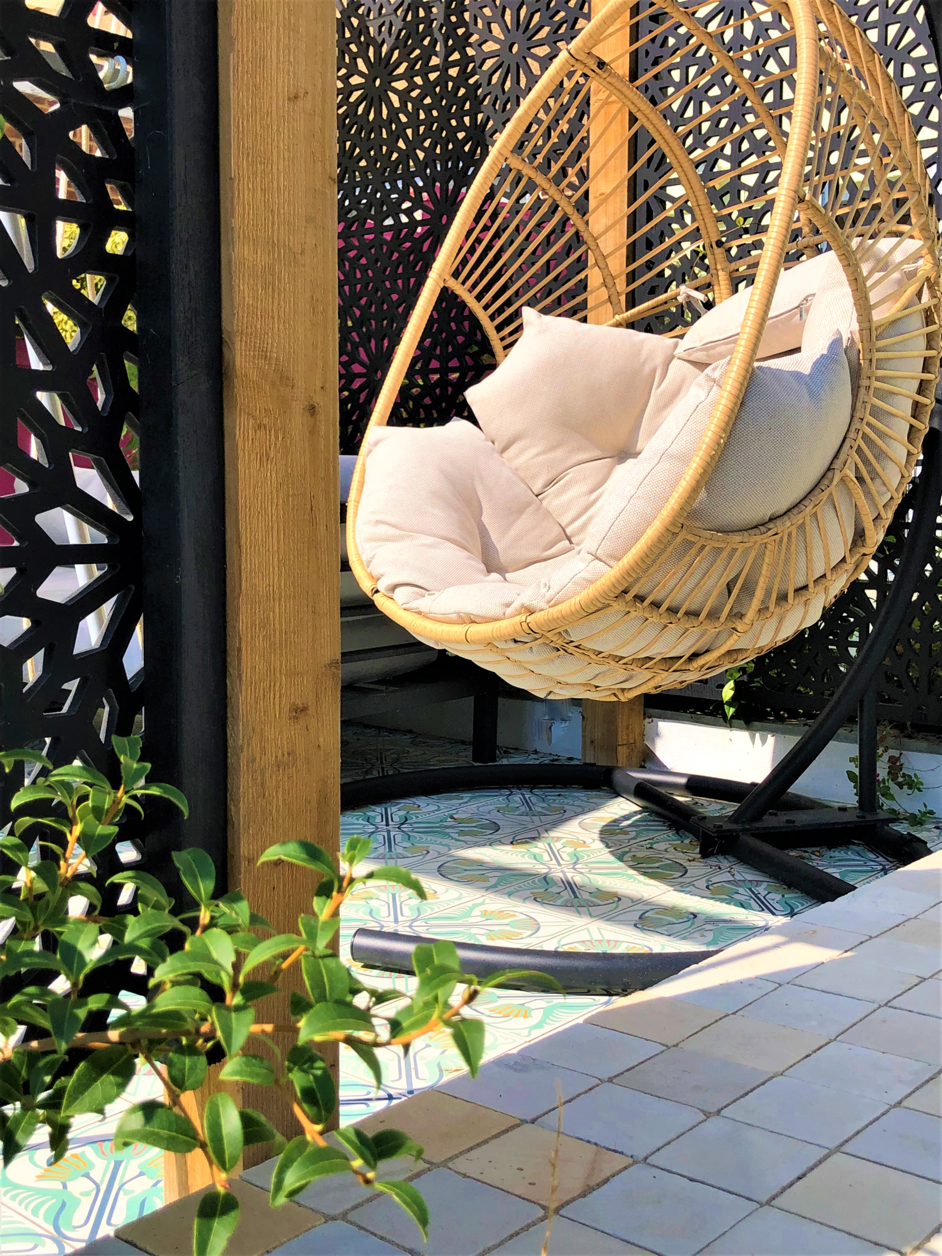 The egg chair on Jungle Bliss tiles in a Bexley garden Alt text:<br />
Bexley garden egg chair over Jungle Bliss Moroccan encaustic cement tiles, framed by Moucharabiya screen