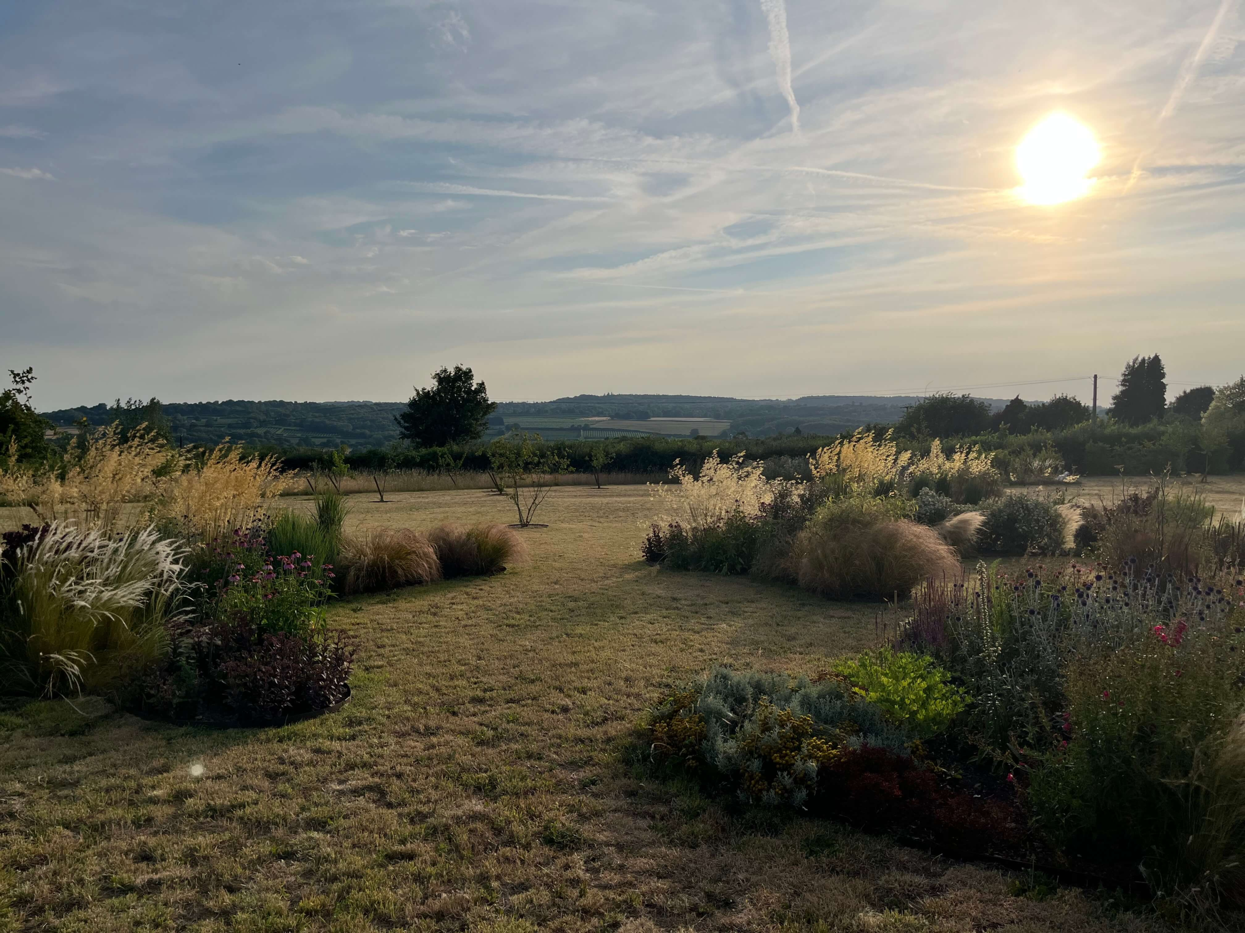 Country garden design in Kent - naturalistic borders of grasses and perennials with mown paths and countryside views