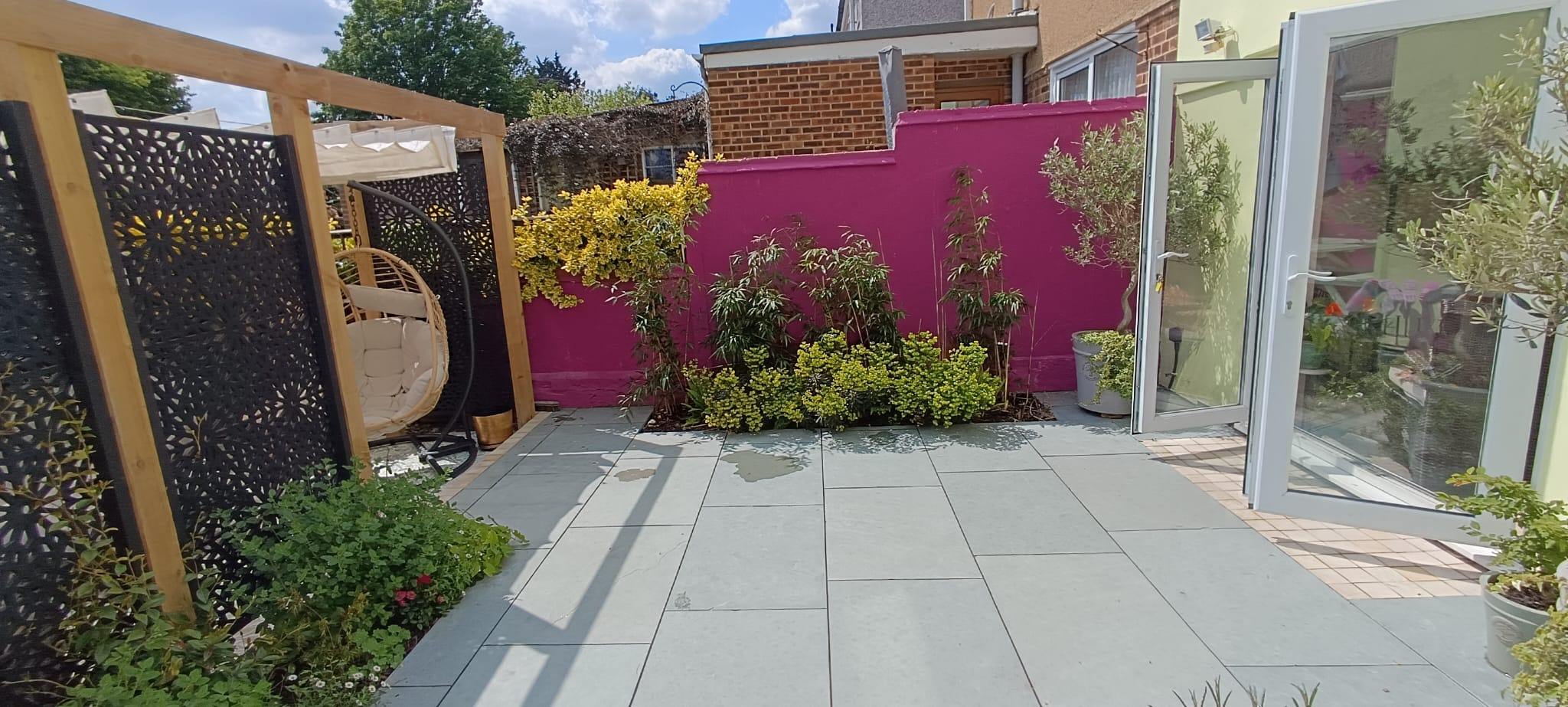 Cerise wall and bamboo planting in a Bexley courtyard Garden design in Bexley, Kent - grey limestone paving, cerise wall and bamboo planting in a Moroccan-inspired courtyard<br />